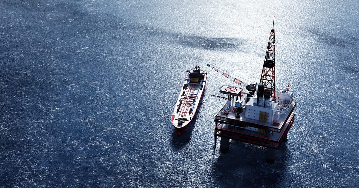 Oil platform on the ocean. Offshore drilling for gas and petroleum. Supply vessel alongside. Industrial