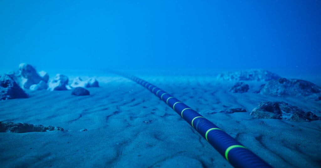Underwater fiber-optic cable on ocean floor.
