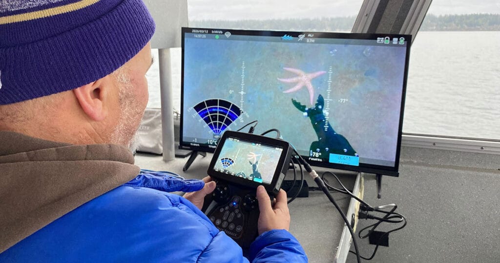 A researcher operating an ROV from a ship using an external monitor.