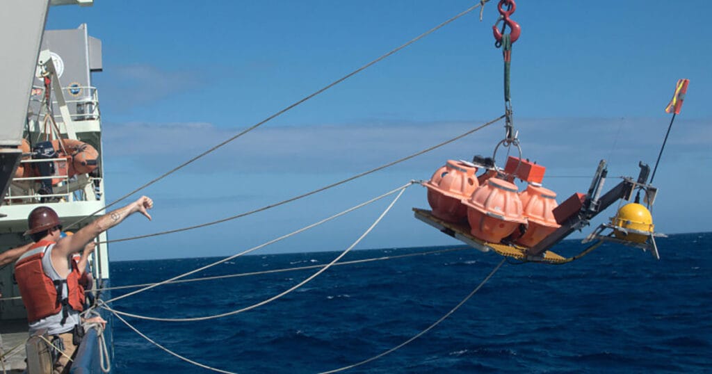 Crew deploy an ocean bottom seismometer off R/V Roger Revelle.