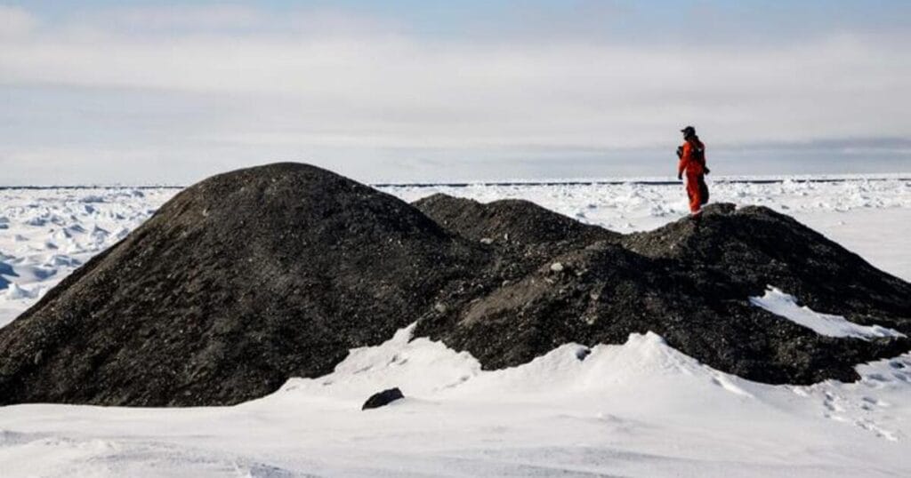 Researchers examine an iceberg with debris on its surface in the Fram Strait.