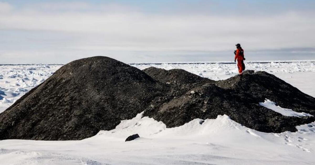 Researchers examine an iceberg with debris on its surface in the Fram Strait.