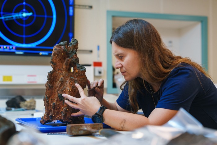 Dr. Olivia Soares Pereira (Monterey Bay Aquarium Research Institute) carefully removes biological samples from the tip of a hydrothermal vent chimney recovered from a newly discovered site. The science team uses the Remotely Operated Vehicle (ROV) SuBastian to gather geologic, biological, and water samples, as well as sensor readings and push cores at depth, for analysis in the ship’s labs. (Image credit: Alex Ingle, Schmidt Ocean Institute)