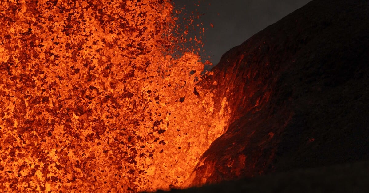 Telephoto view of the north vent lava fountain during episode 49 on June 14, 2026, showing the incandescent lava landing on and illuminating the Halema'uma'u crater wall. (Image credit: T. Paladino)
