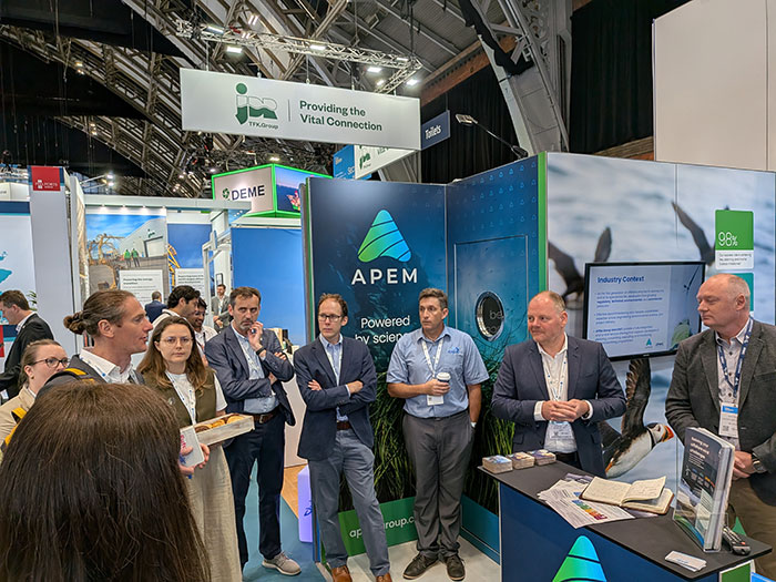 Delegates gather at the APEM Group exhibition stand during RenewableUK’s Global Offshore Wind, showcasing expertise in environmental consultancy, marine services, renewable energy and data-driven environmental intelligence. 