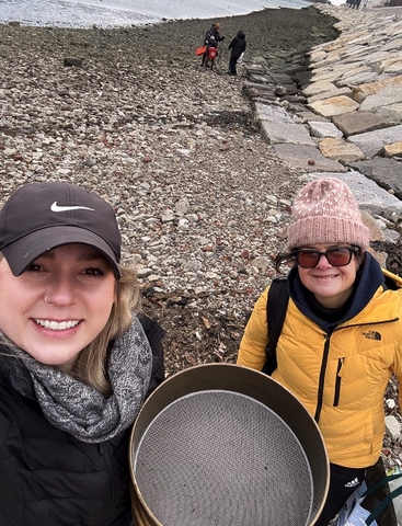 Aly Putnam (left) and Carolina Bastidas conducting a winter sample. Top: Empty Manila clam shells blanketing the intertidal zone in Boston Harbor’s Spectacle Island. (Image credit: UMass)