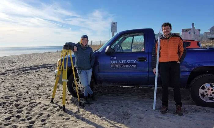 URI GSO students Emily Hall (left) and Dasan McElroy get ready for another beach survey in December 2022. Hall and McElroy earned their master's degrees in oceanography in 2023 and 2024 respectively. Hall is now a coastal geologist for the Rhode Island Coastal Resources Management Council. (Image credit: URI)