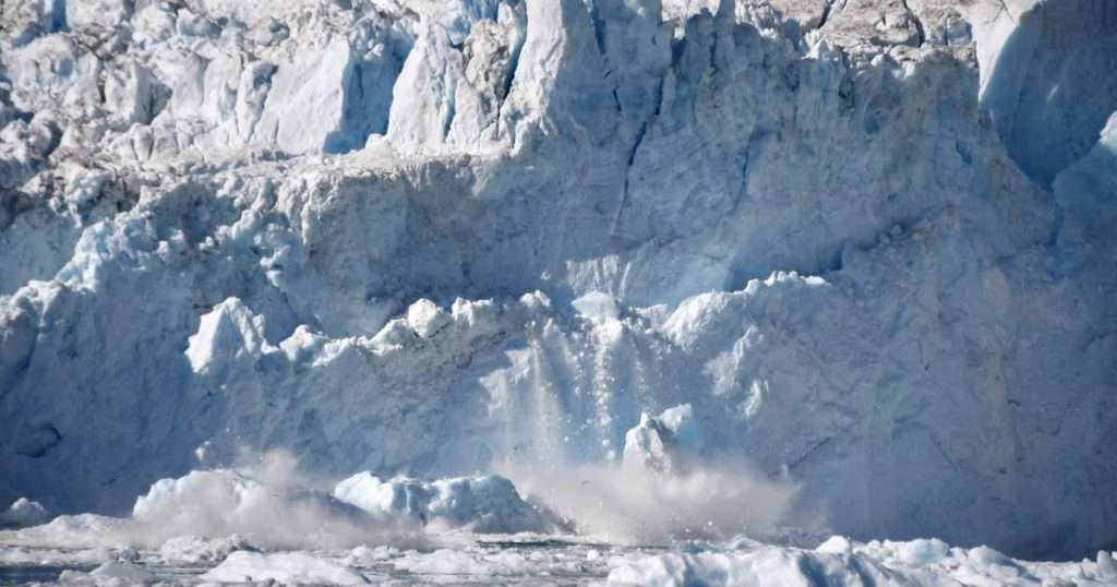 Rumleren Glacier calves ice from its face in South Skjoldungen Fjord, Greenland. Calving is one of the processes scientists are examining to better understand how ice cliffs break apart and retreat. (Image credit: Catherine Walker, WHOI)