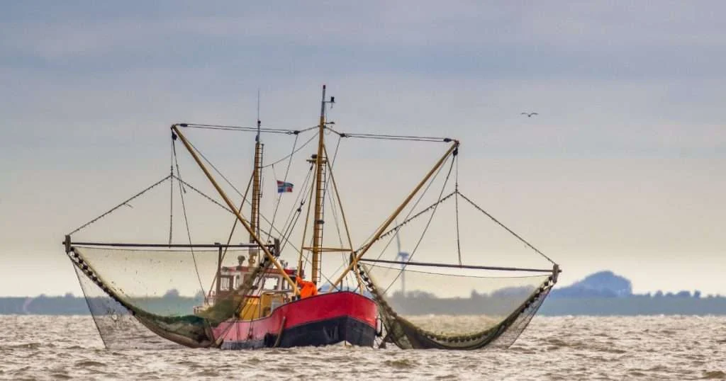 A US fishing boat with nets out on the water. (Credit: NOAA Fisheries)